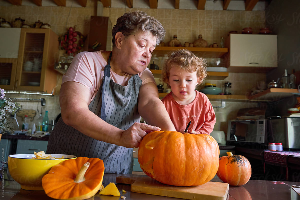 Grandmother and granddaughter carve a pumpkin for the holiday