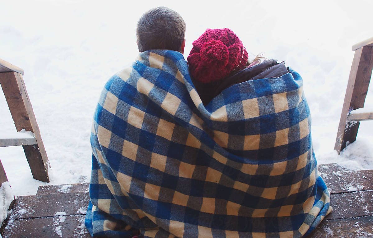 Couple Cuddled Together Under Blanket Sitting On Porch On Winter Day By Stocksy Contributor 7661