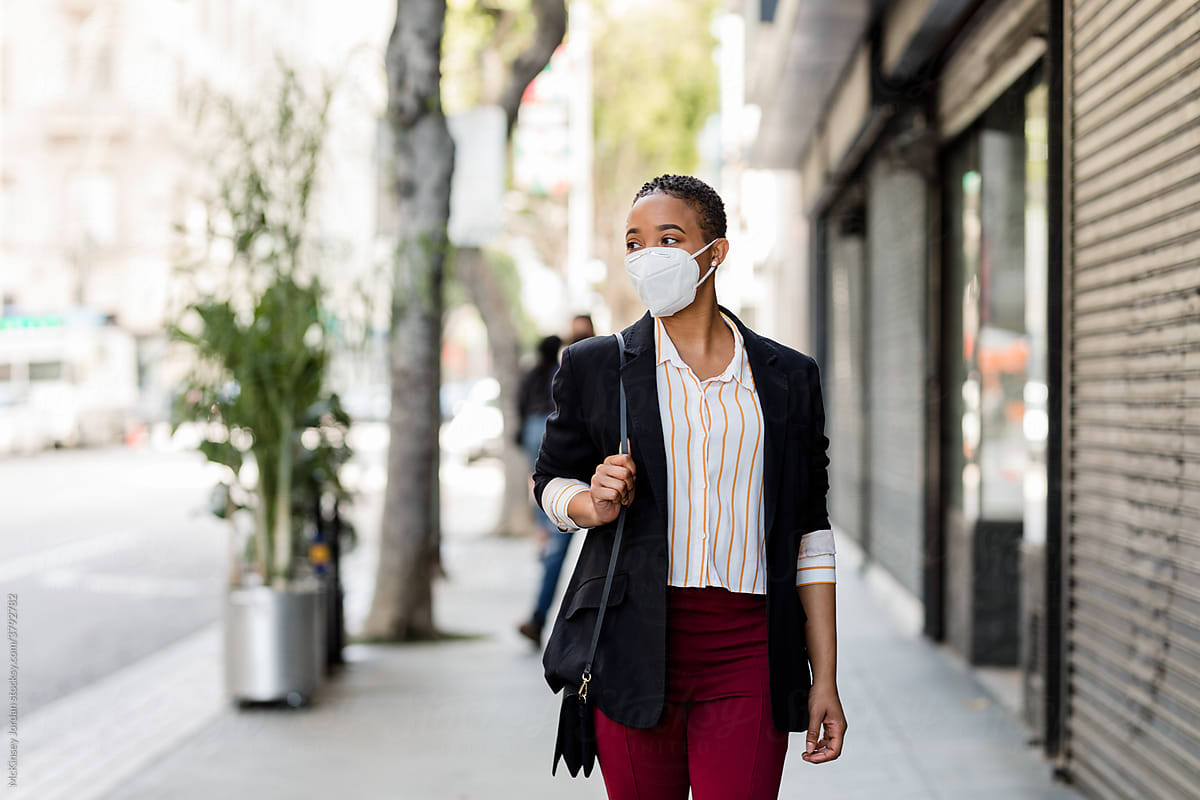 Business Woman Wearing a Mask Walks Down an Empty City Street