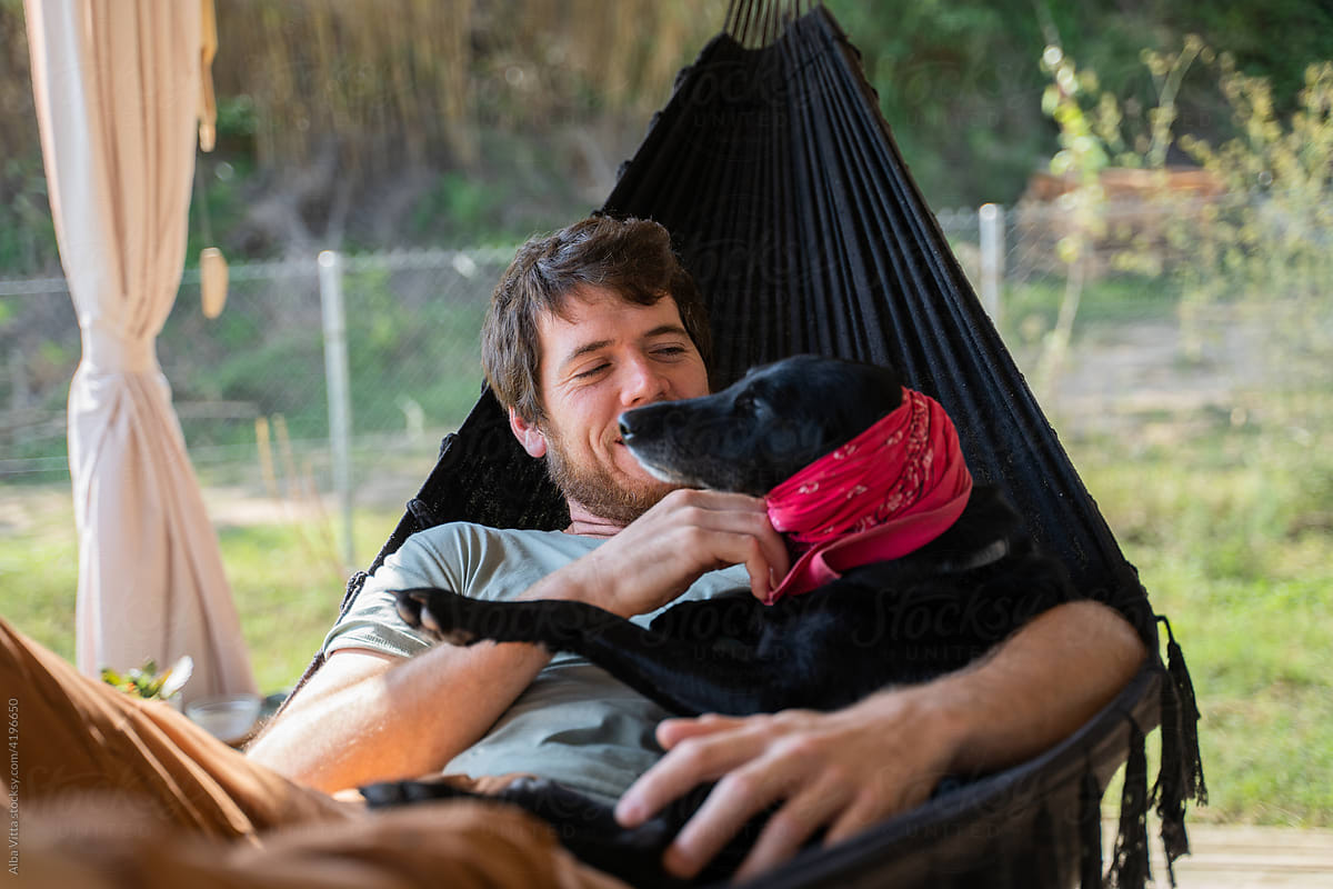 Man with dog relaxing in hammock