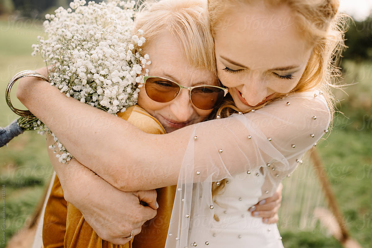 adult daughter tightly hugs with mother