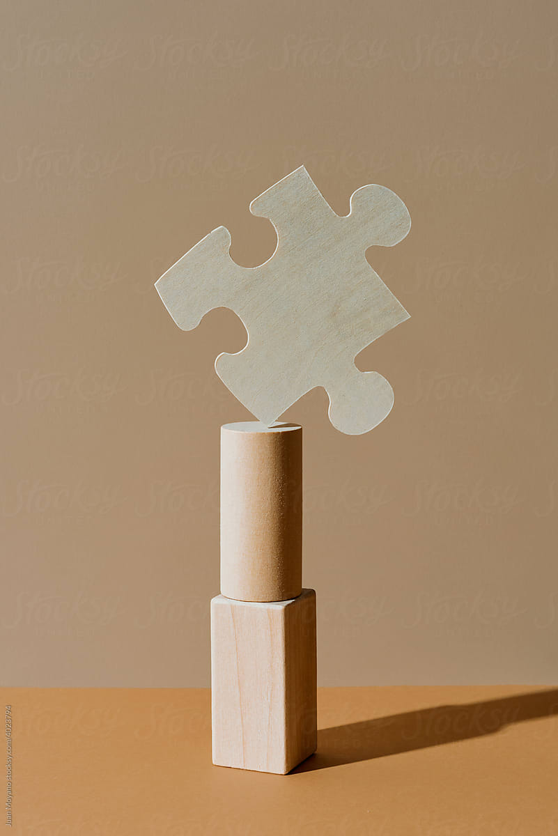 puzzle piece in balance on a stack of building blocks