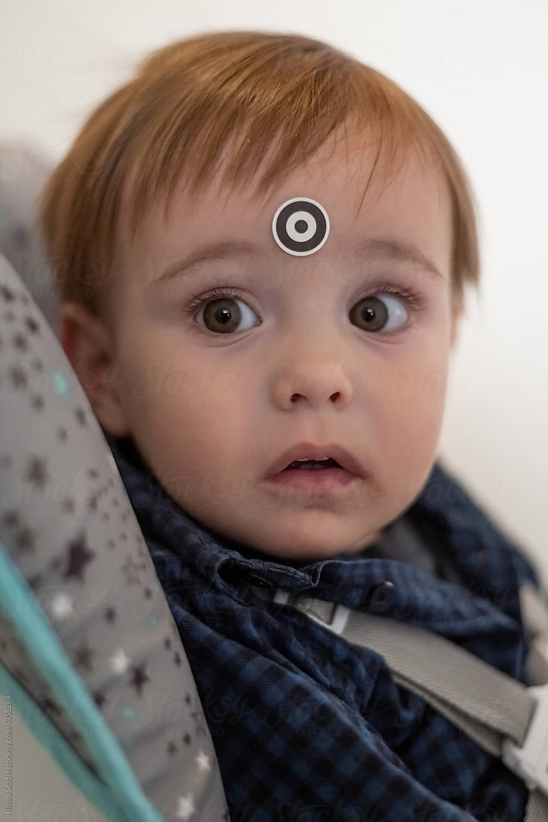 Baby Boy with sticker for calibration of eyetracking machine