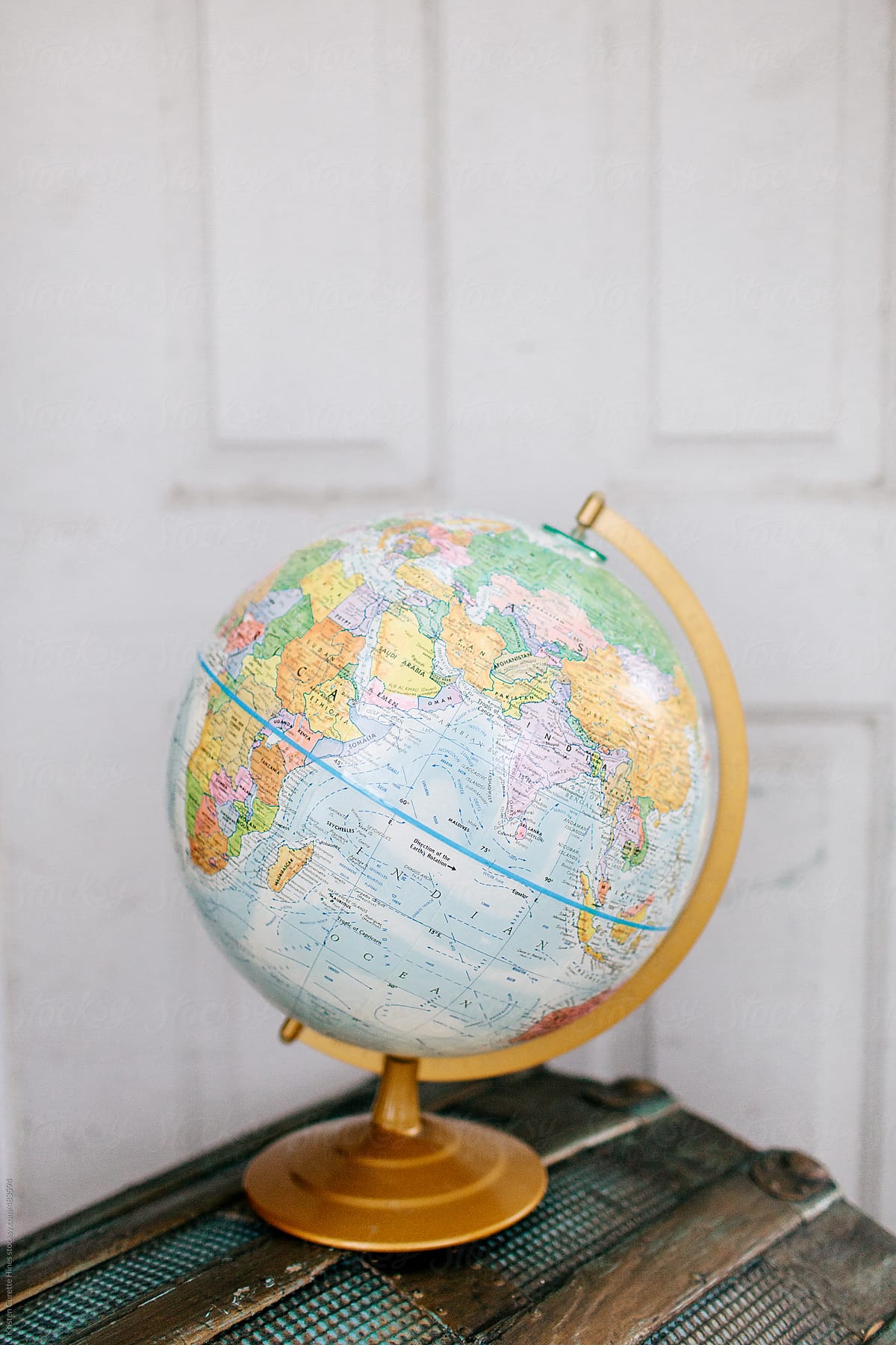 A world globe sitting on an antique storage chest.