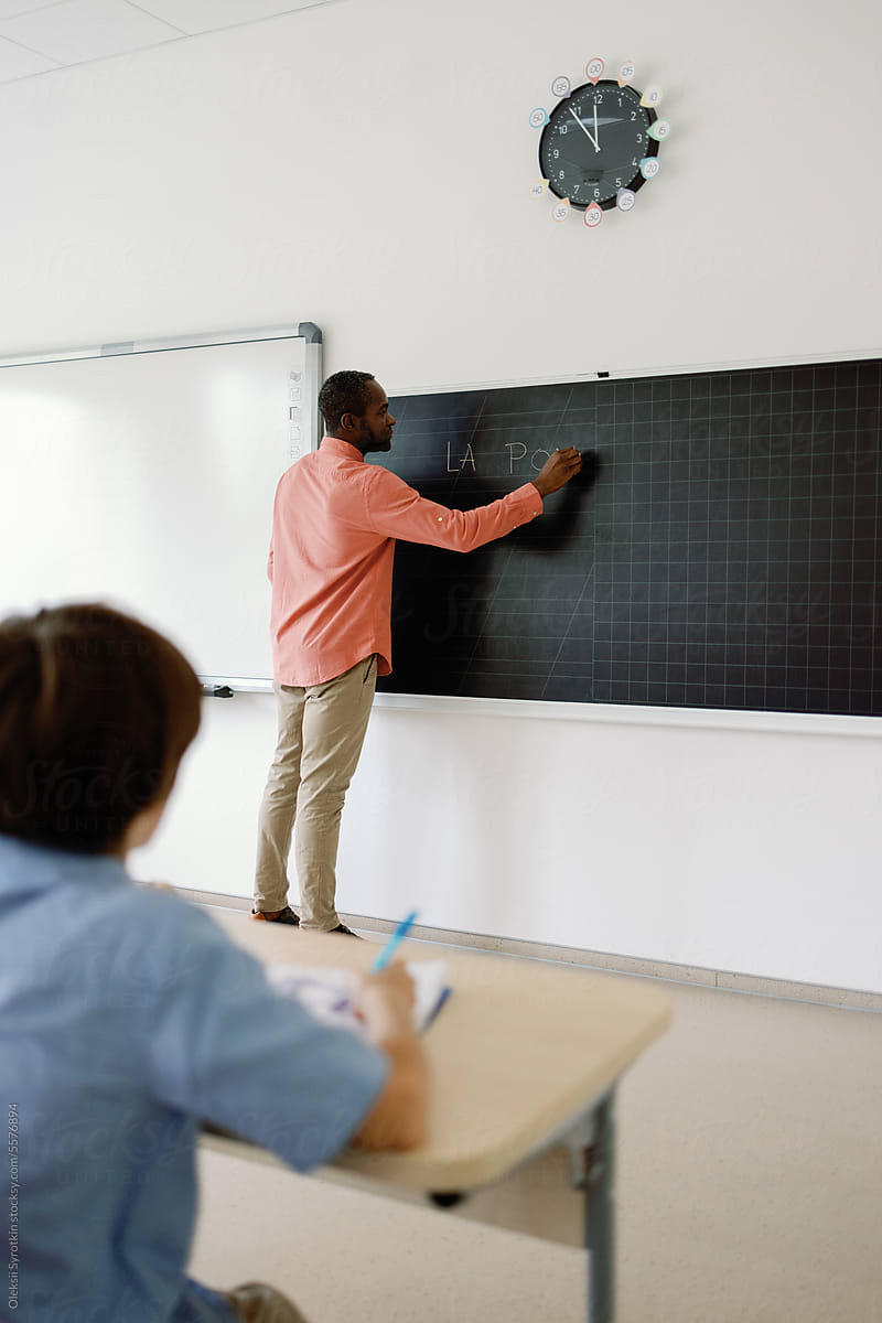 Head teacher writing blackboard classroom lesson education