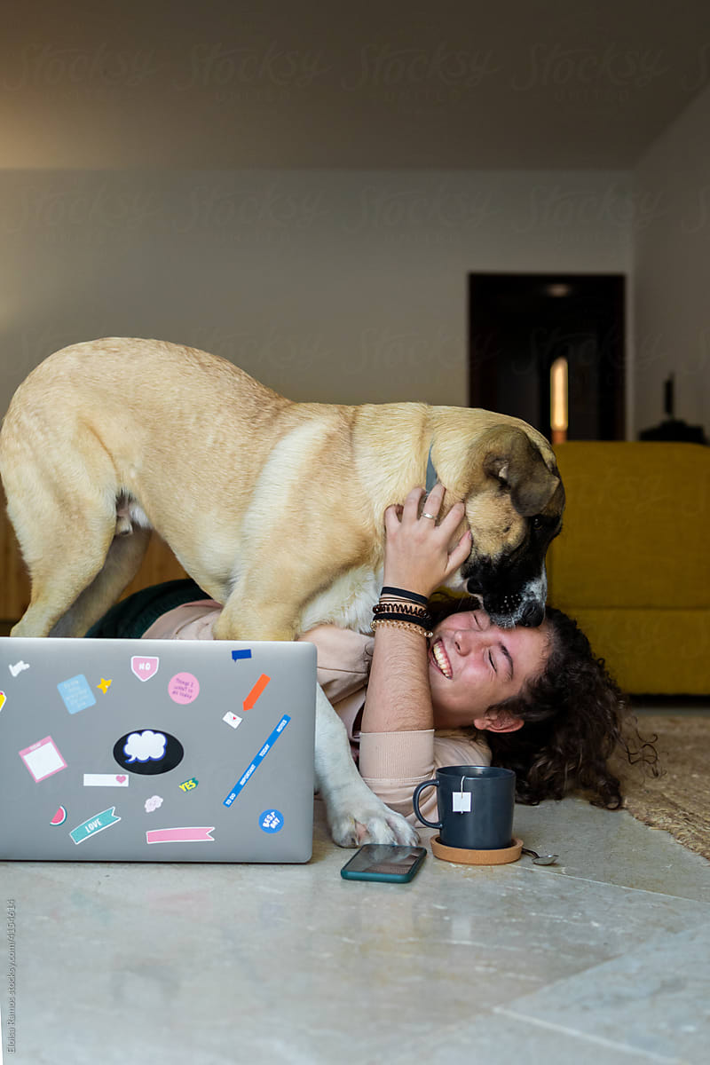 young  girl doing homework and having fun with a her pet