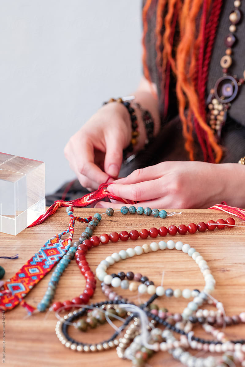 Crop female artisan crafting bracelet on table