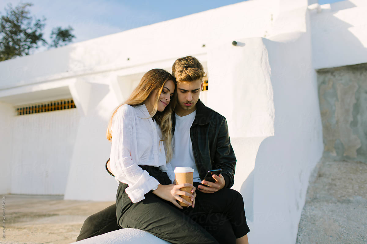 Cozy Couple with Coffee using a smartphone