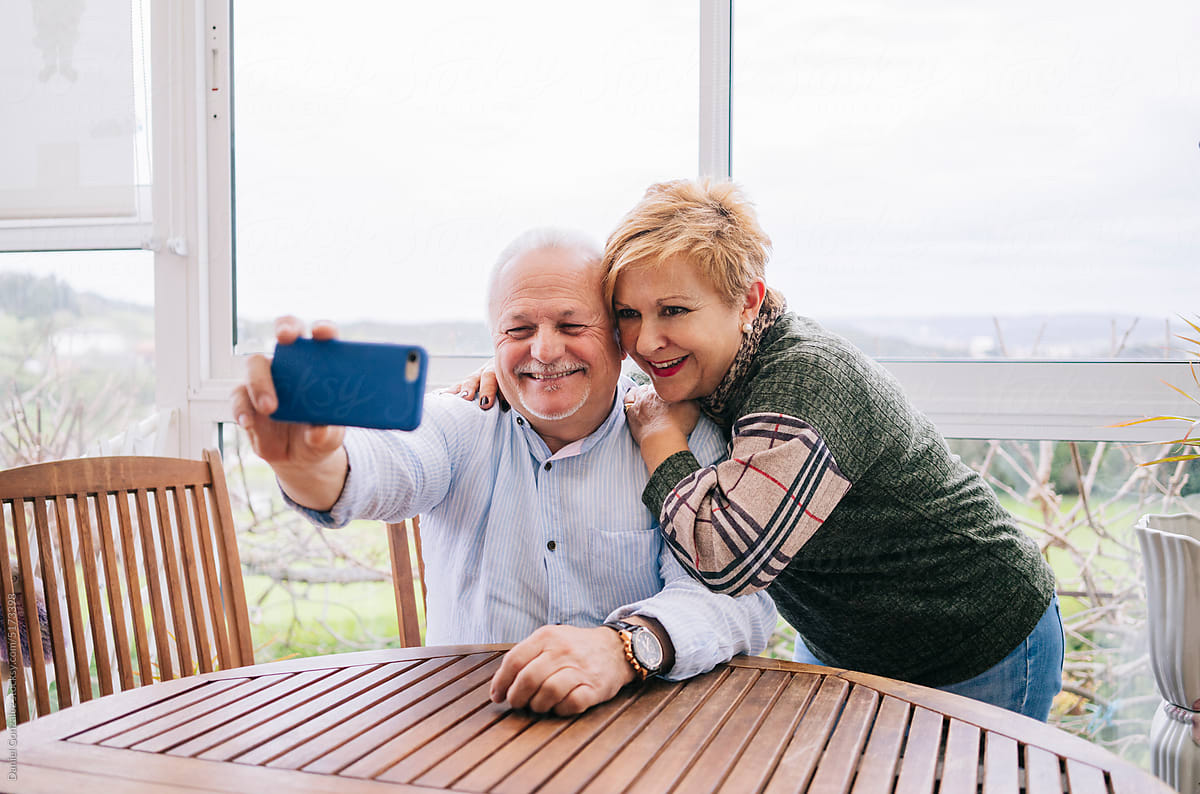 Cheerful senior couple taking selfie on smartphone