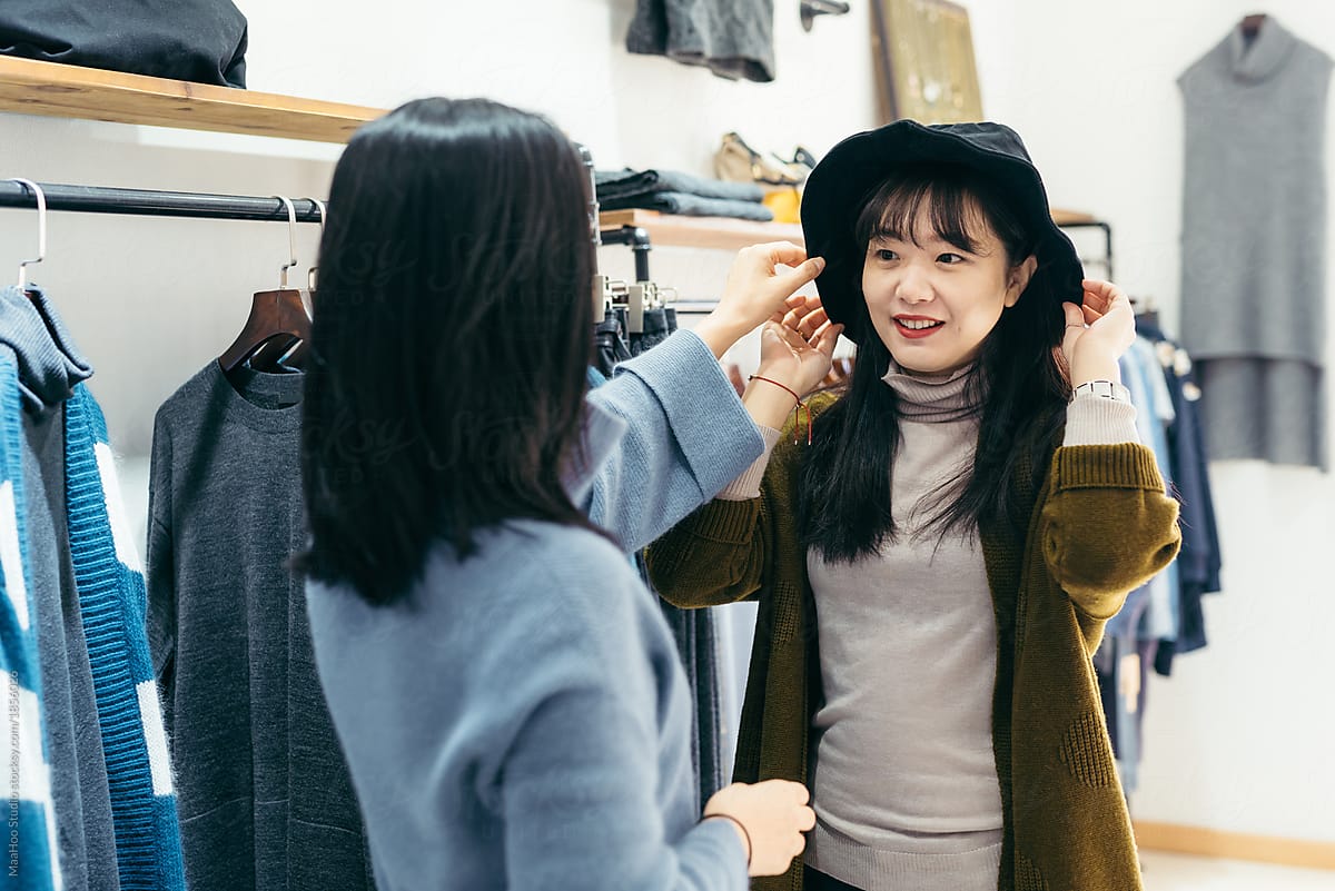 Young woman trying hat in clothing store