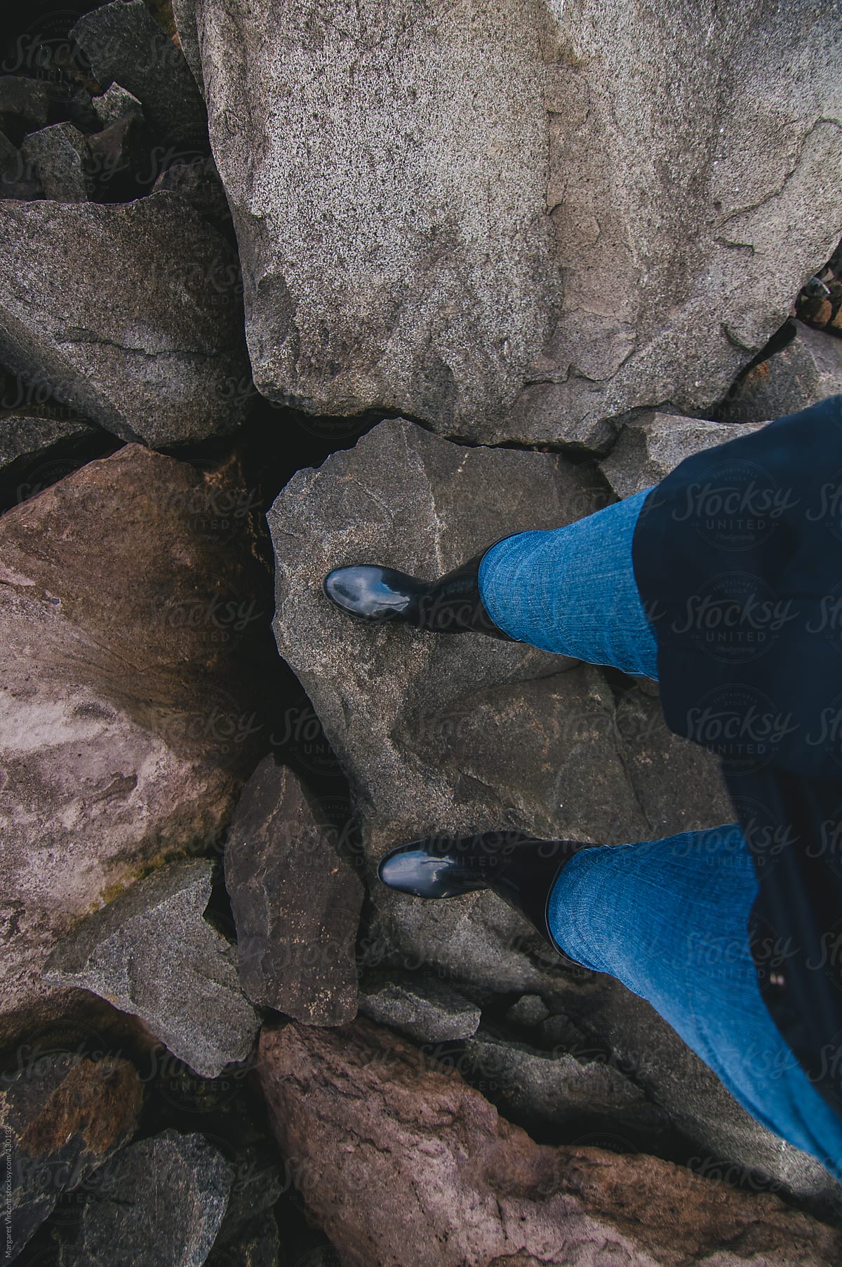 woman's legs and feet climbing on rocks