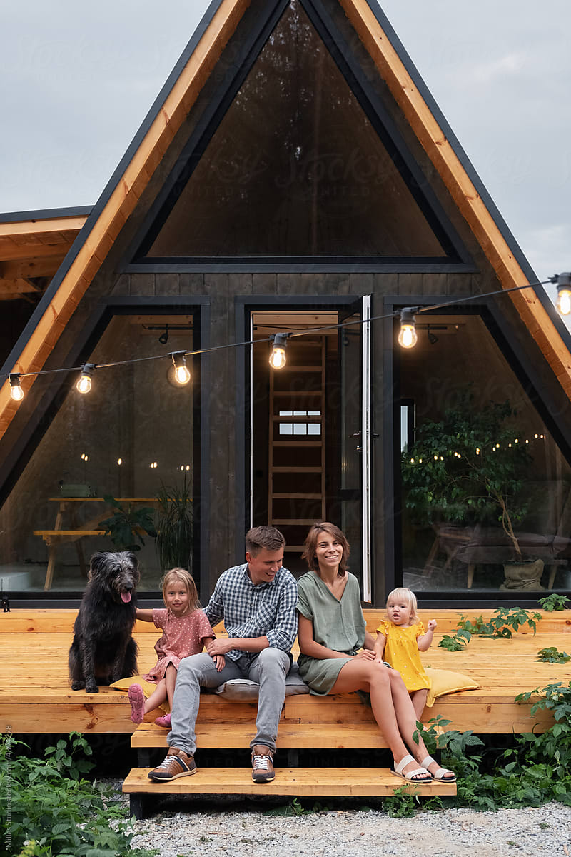 Happy family with dog on house porch in evening