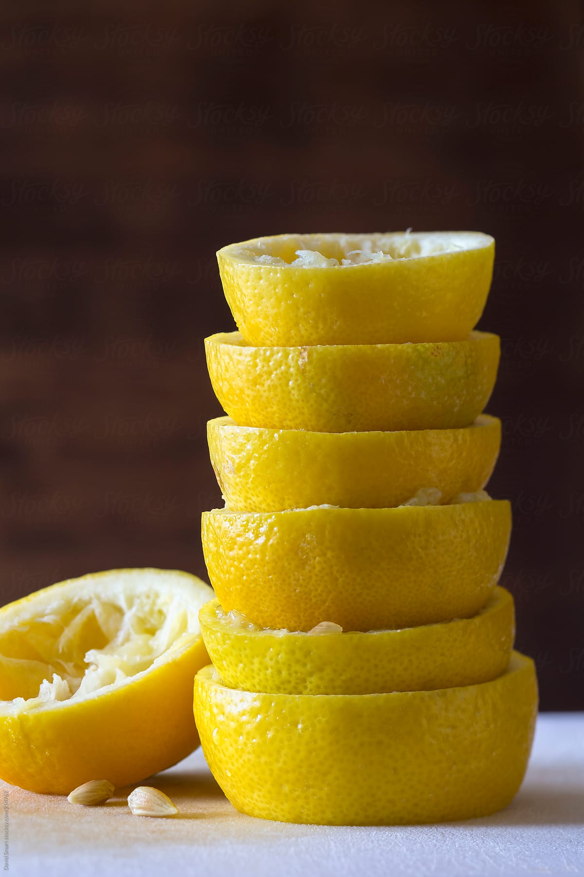 Stack of squeezed lemons on cutting board