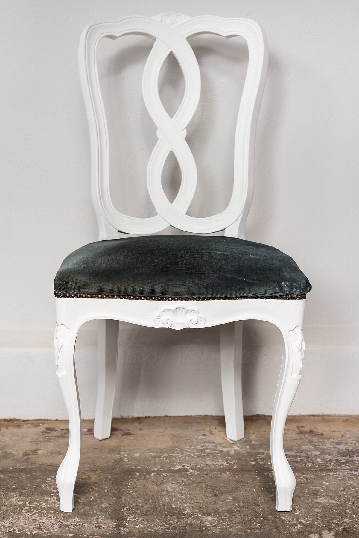 white vintage chair against a plain wall,