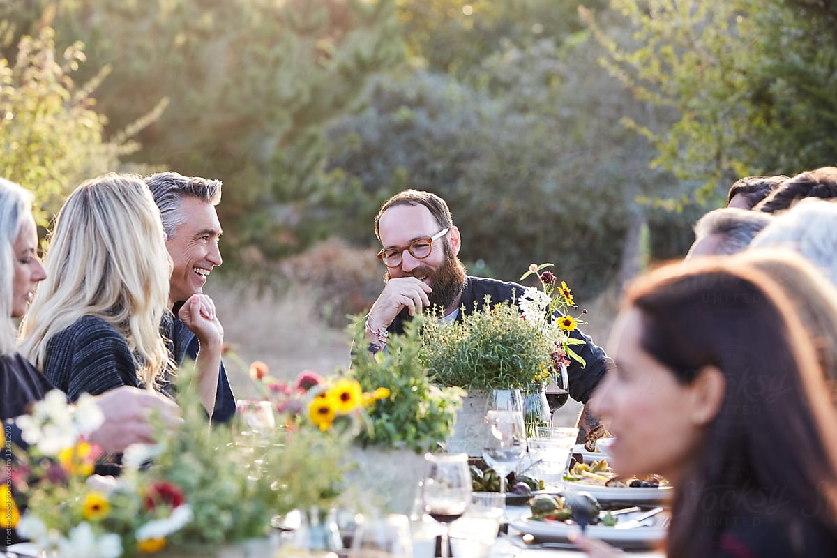 Friends and family laughing together at outdoor dinner