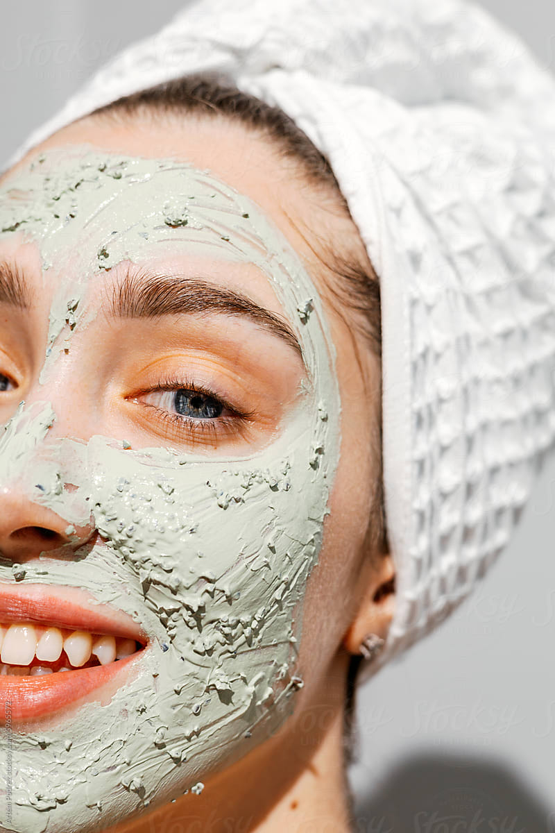 Close-up portrait of a woman with a clay mask on her face, skin care
