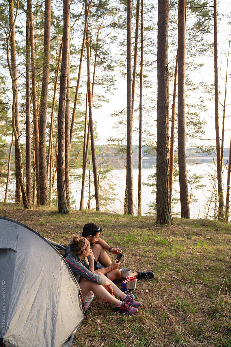 Couple Sitting At The Tent In The Woods