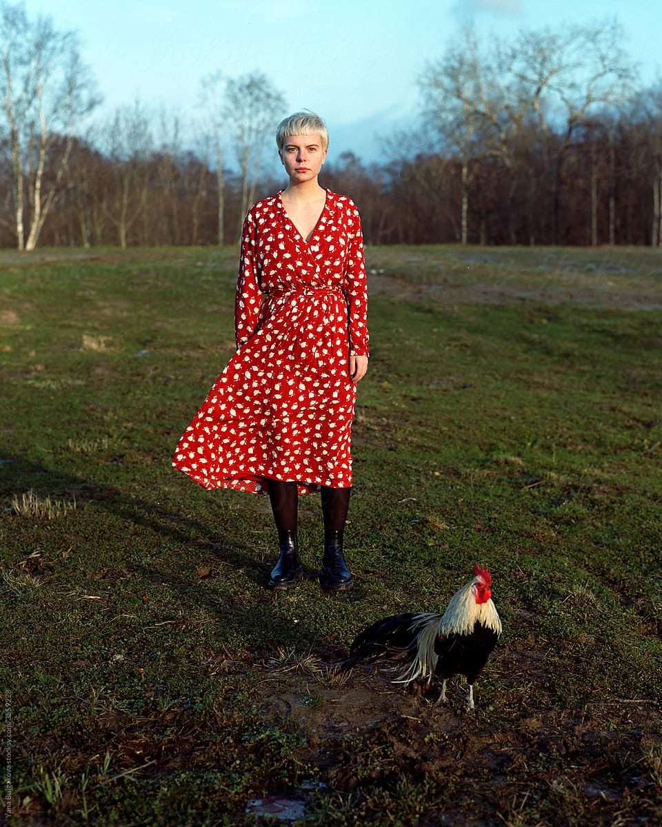Girl standing with the rooster