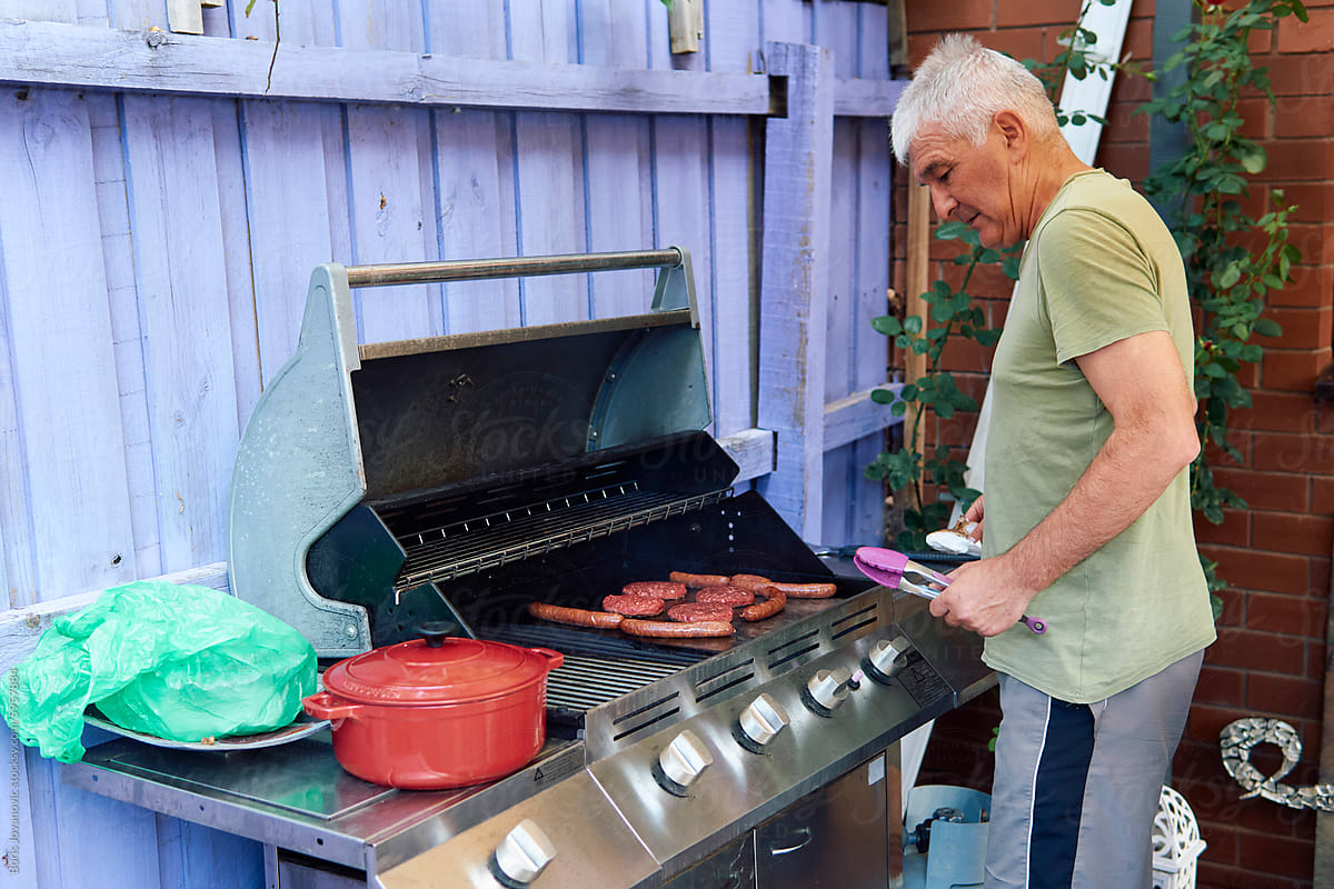 Portrait of a man grilling in the backyard