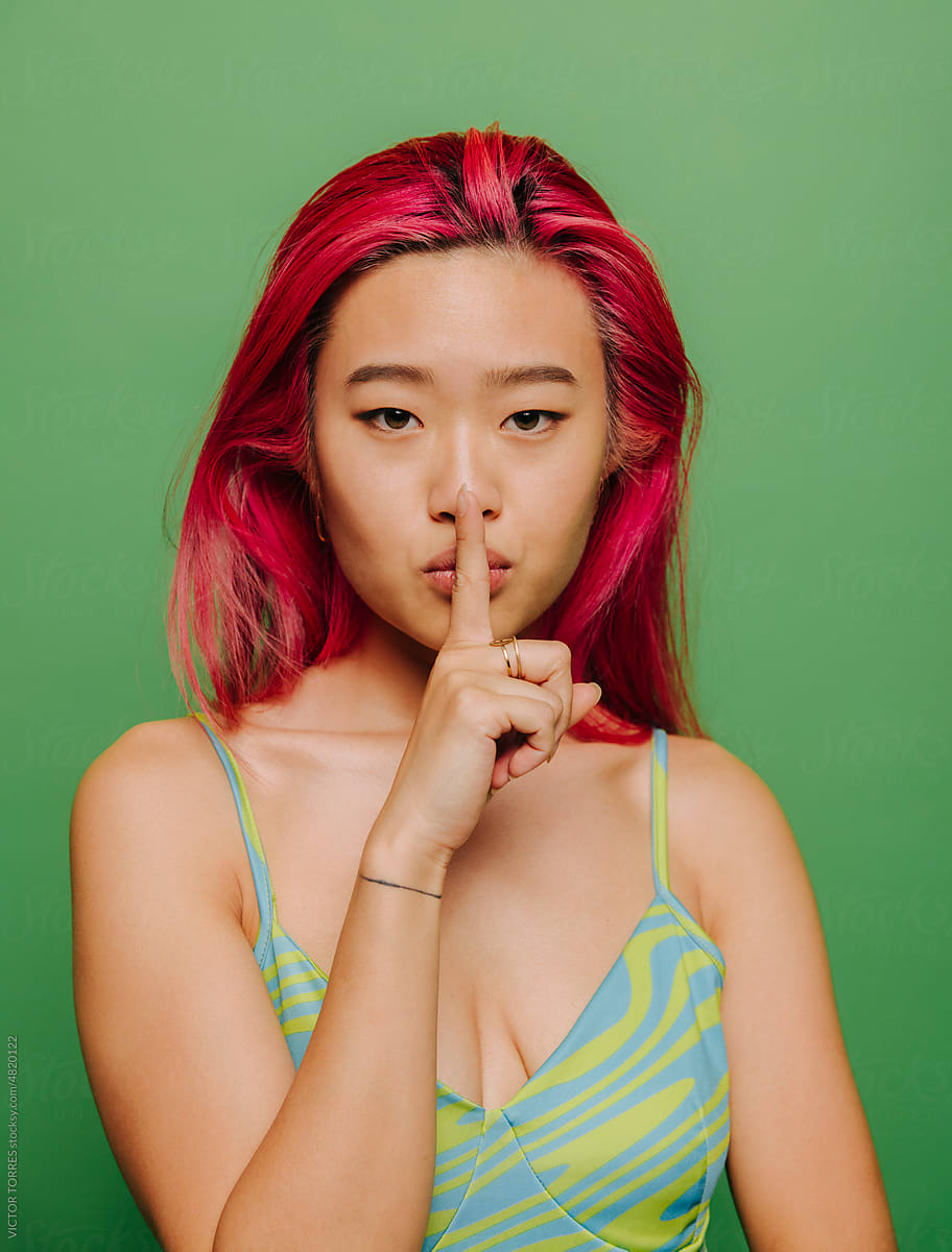 Young woman touching lips asking for silence