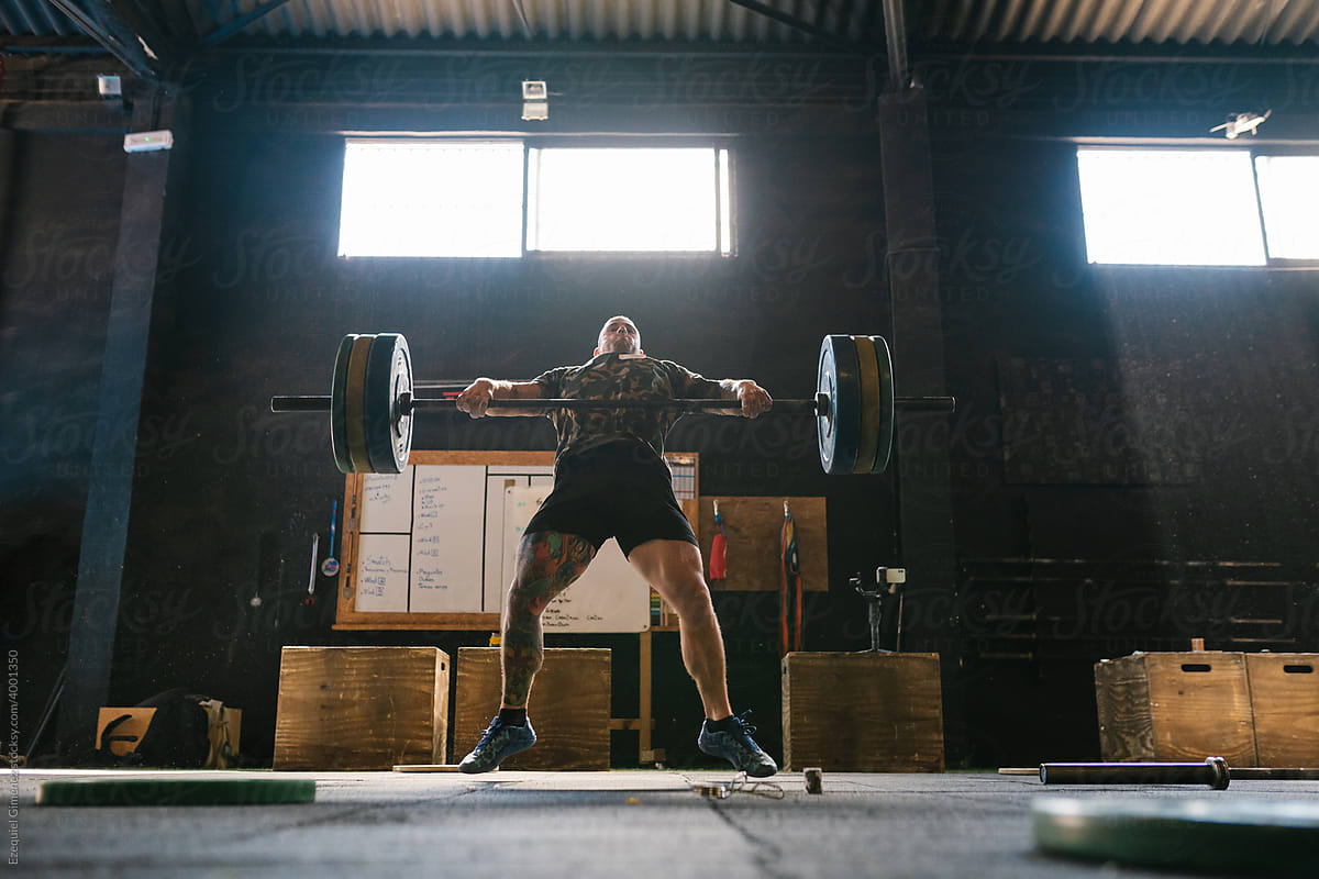 Man exerting great effort to lift a heavy barbell