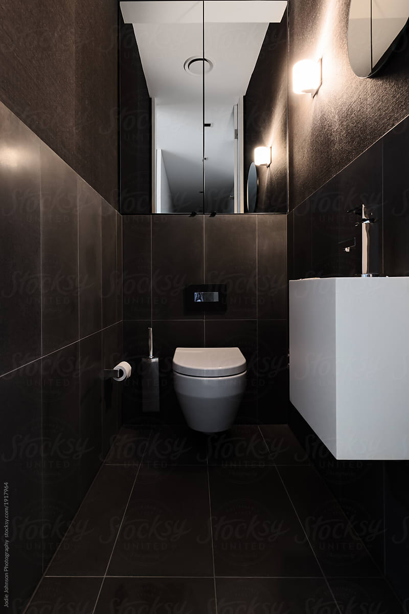 Black tile and wallpaper powder room in a luxury home