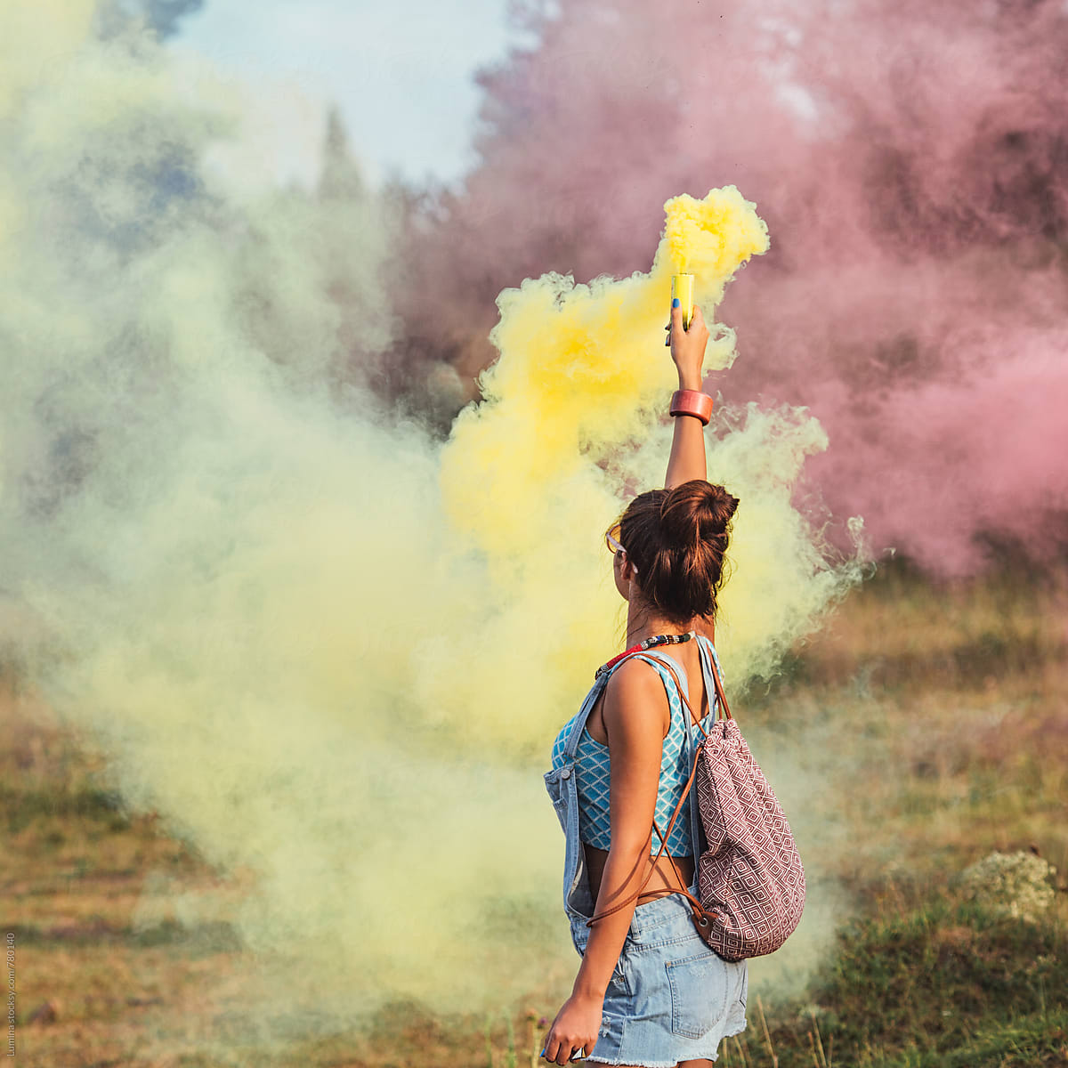 Hand Holding A Pair Of Smoke Bombs by Stocksy Contributor Amy