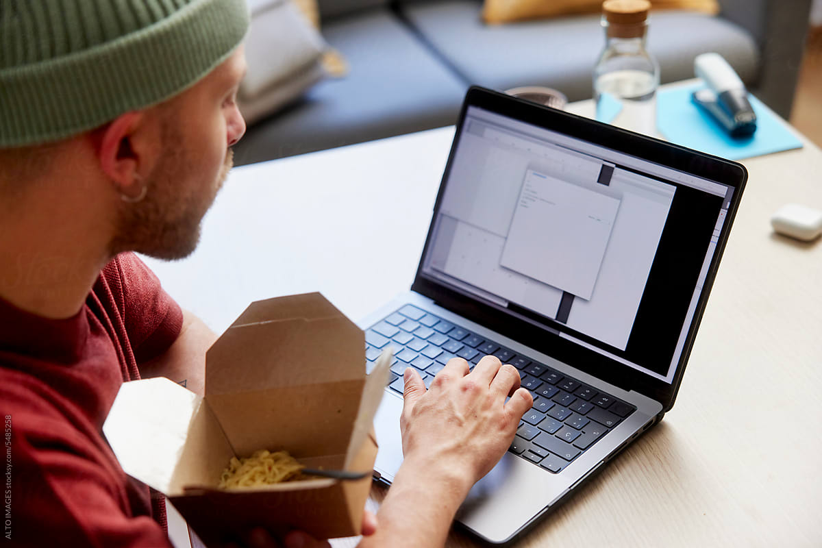 Male freelancer working on netbook during lunch break