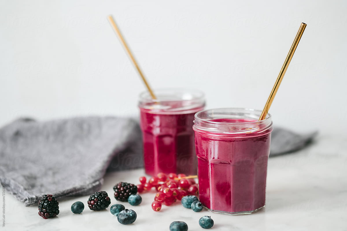 Currant smoothie in glasses with metal straws