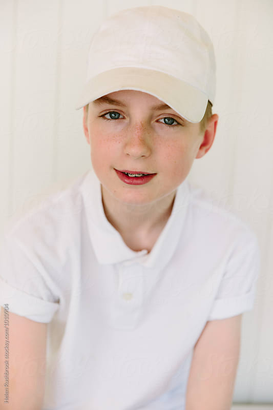 Teenage boy wearing a white baseball cap and polo shirt.
