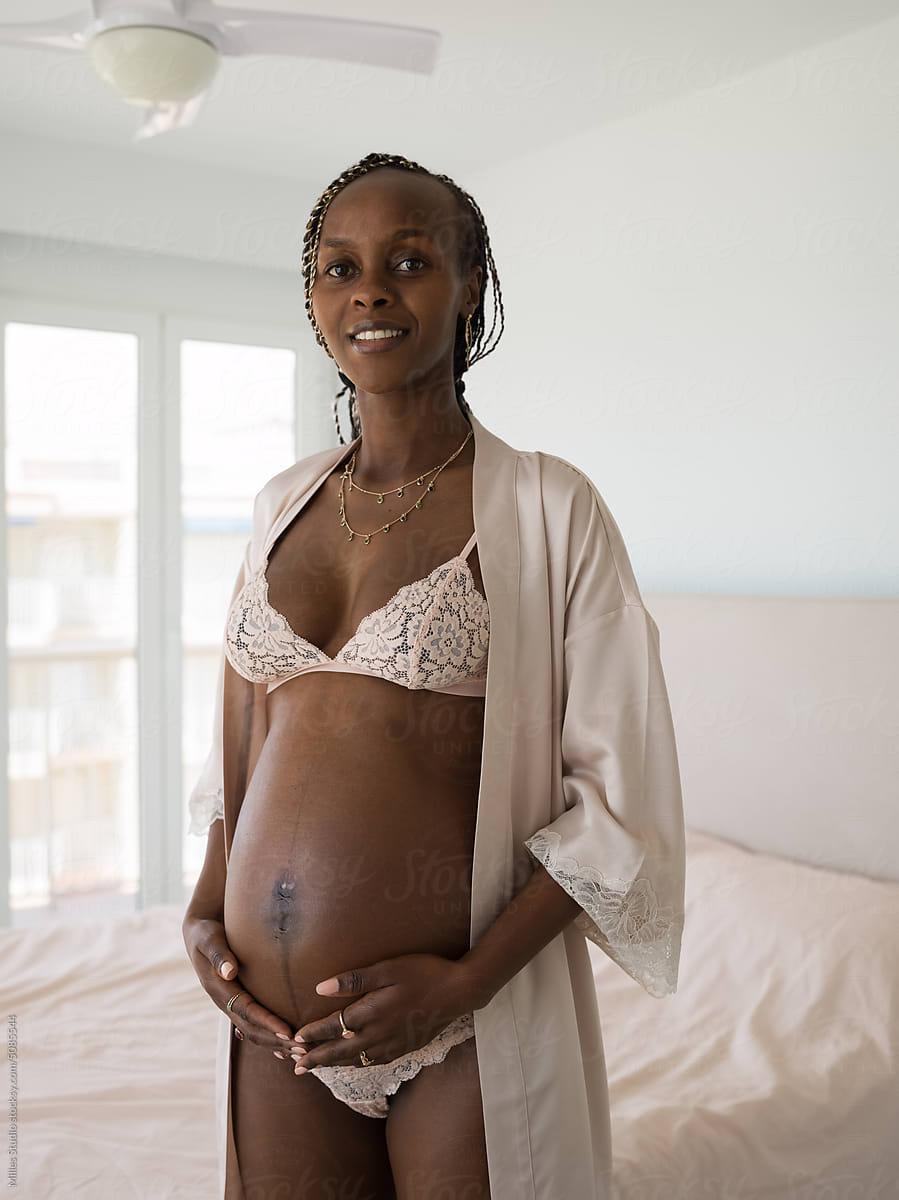 Smiling Black Pregnant Woman In Lingerie by Stocksy Contributor