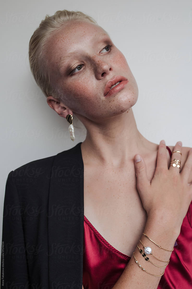 Model wearing red top and earrings