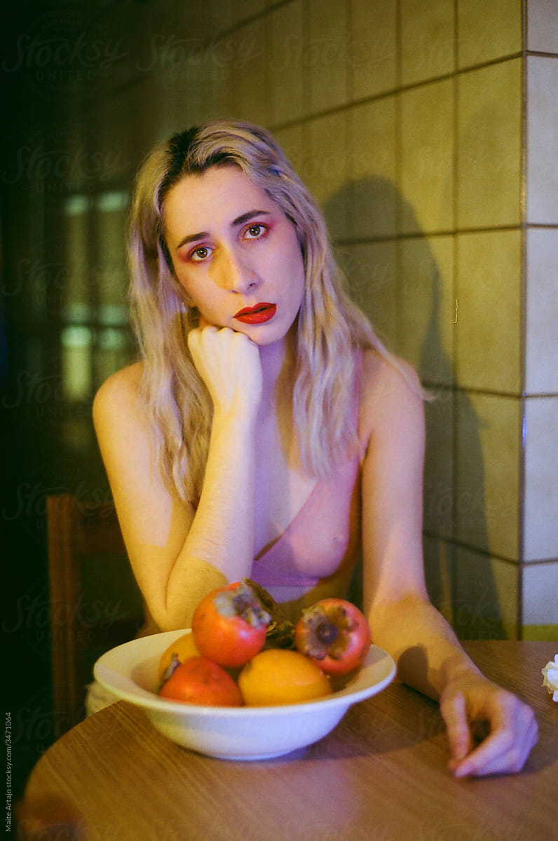 White haired girl bitting a fruit
