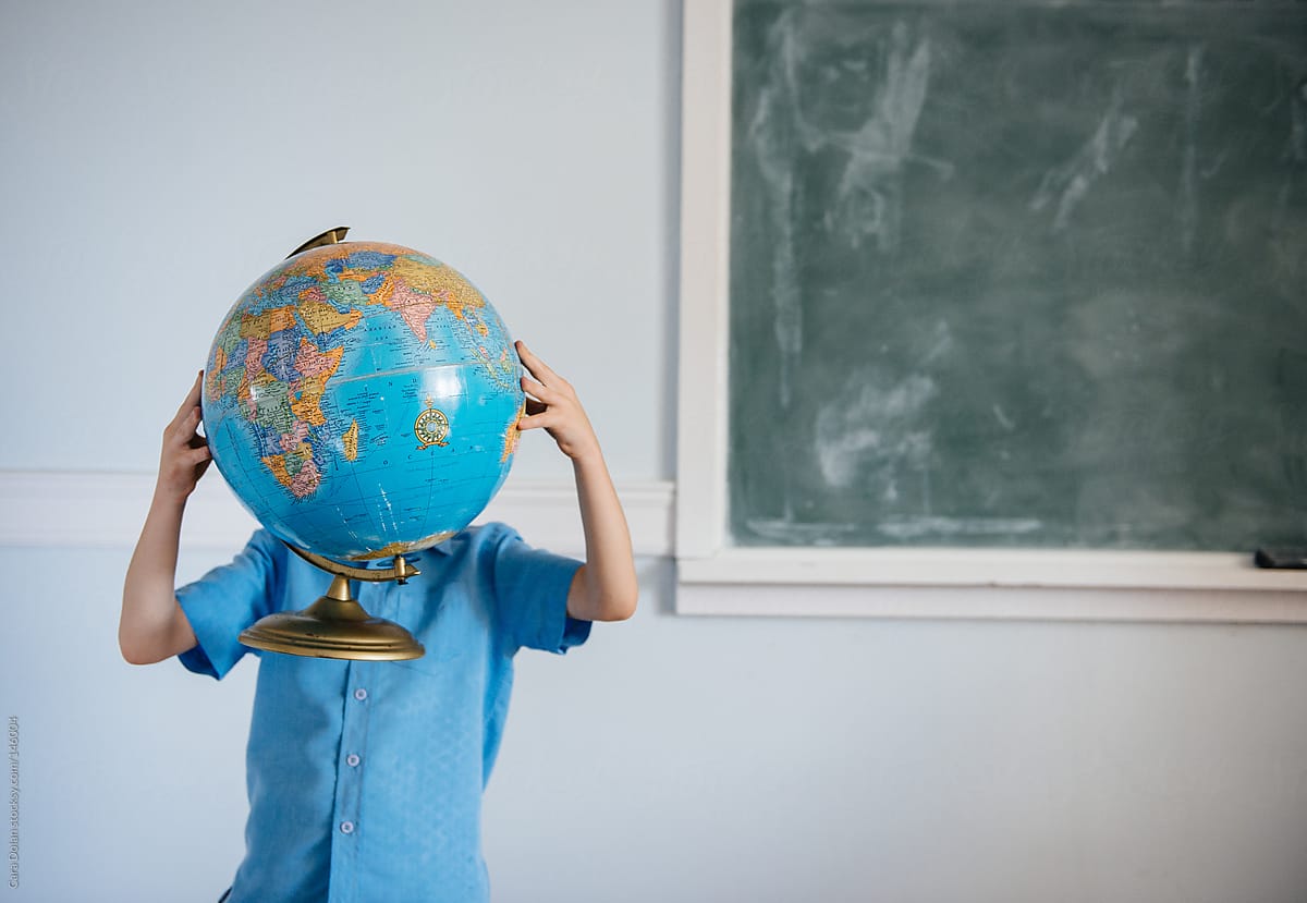 Boy Holds Globe in Classroom