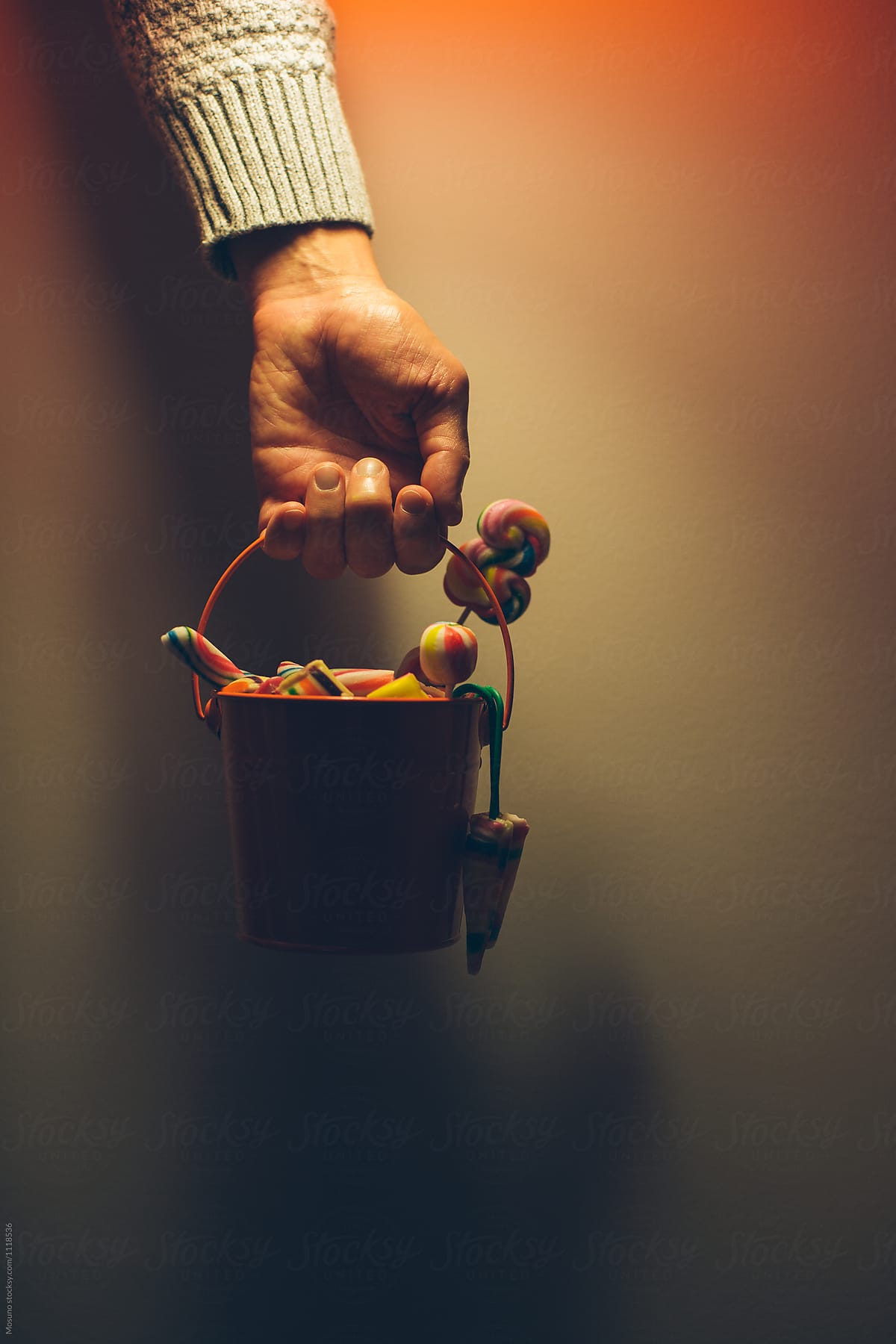 Male Hand Holding Bucket of Halloween Candy