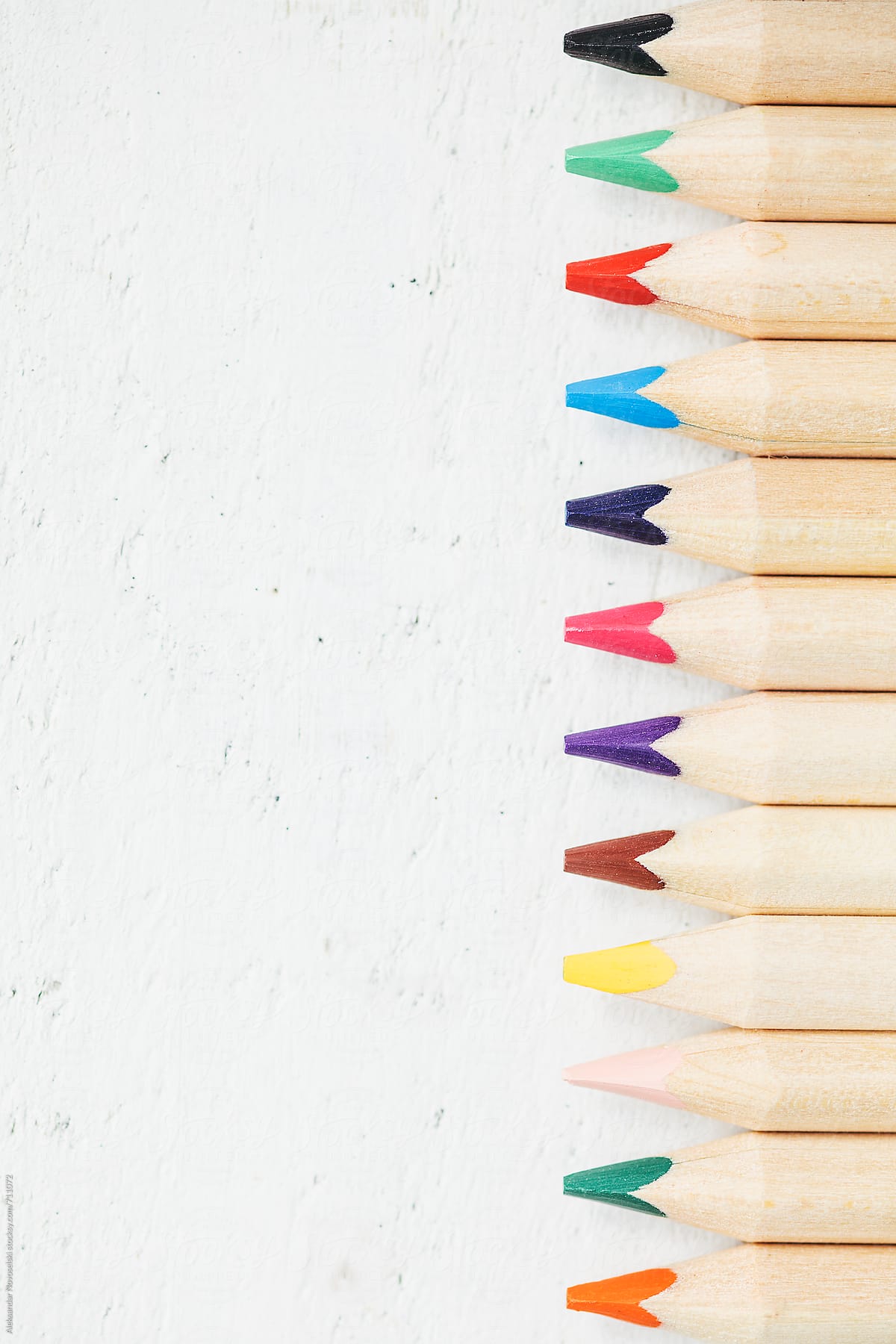 Set of colorful pencils against a white wooden background