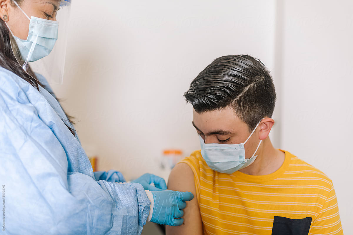 Doctor putting patch on arm of patient after vaccination