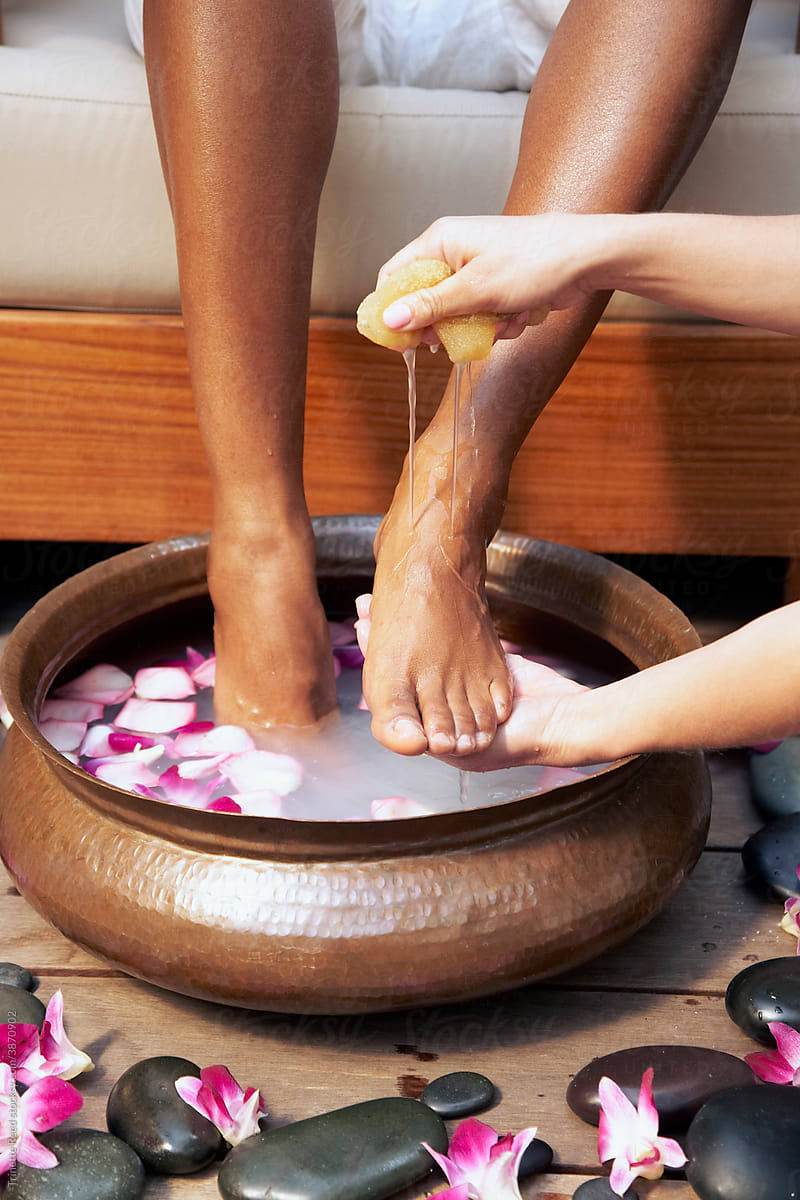 Spa therapist washing woman\'s feet for pedicure