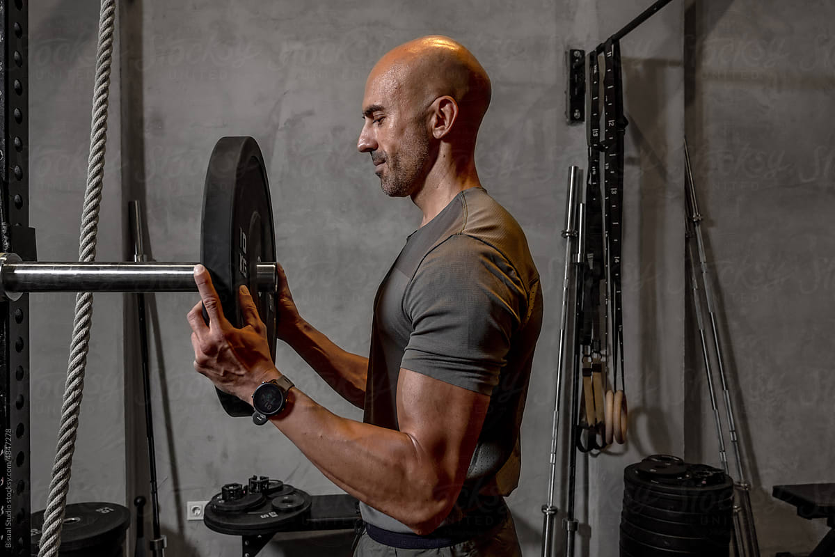 Muscular sportsman preparing for weightlifting workout