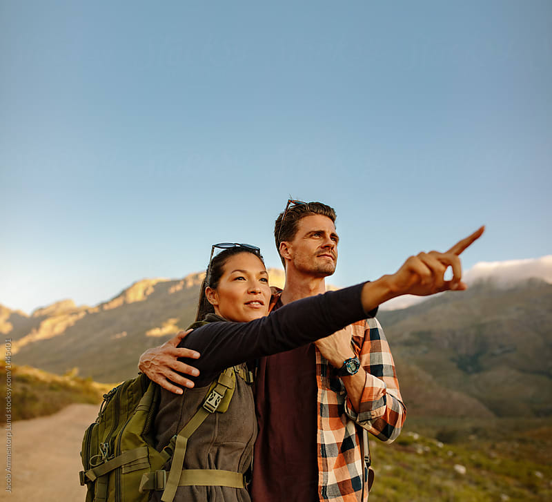 Young hiking couple with woman pointing away