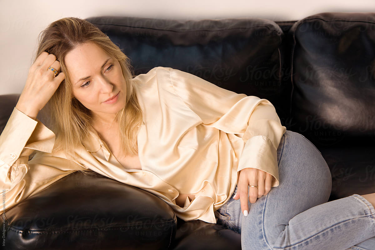 Tender woman in casual clothes relaxing on sofa