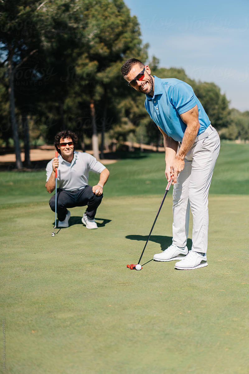 Adult men playing golf together