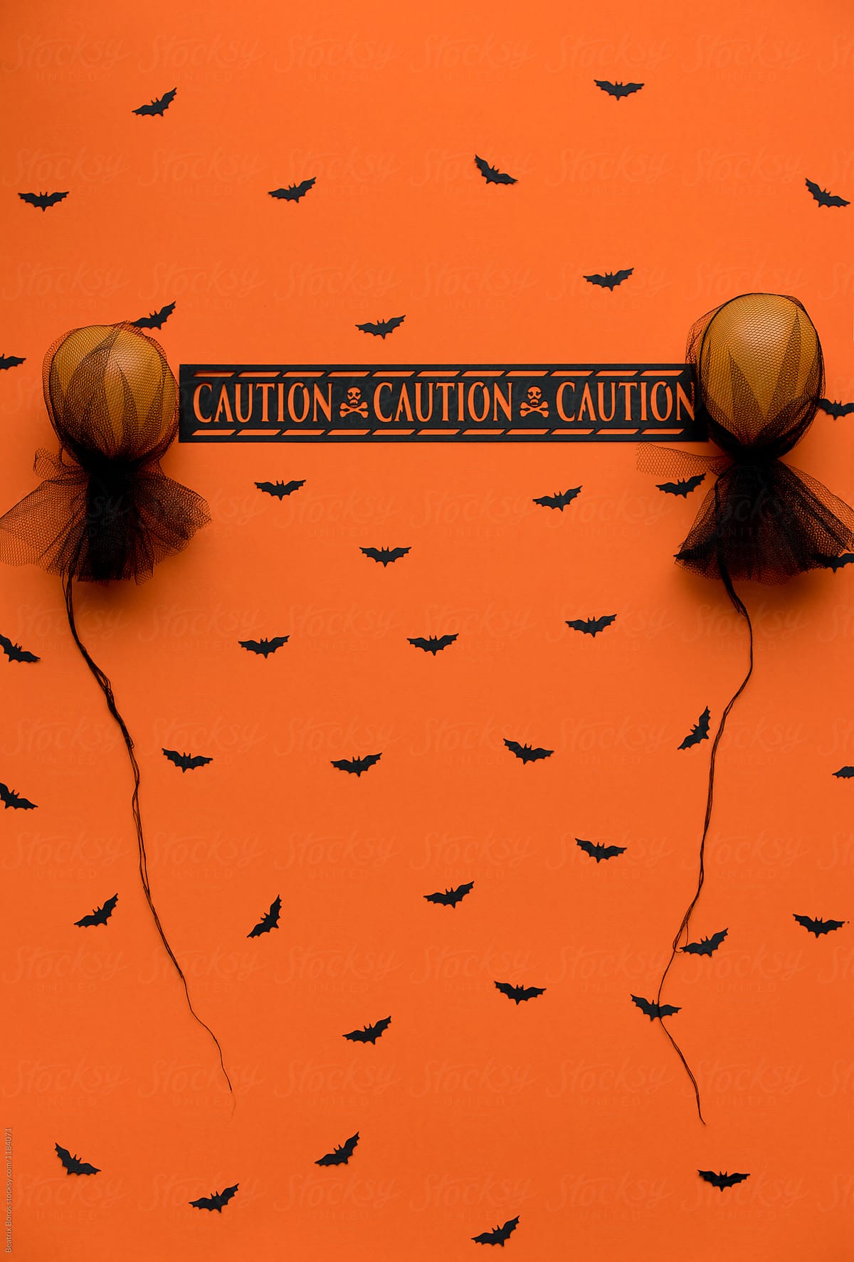 Halloween warning message between 2 orange balloons on a bat pattern
