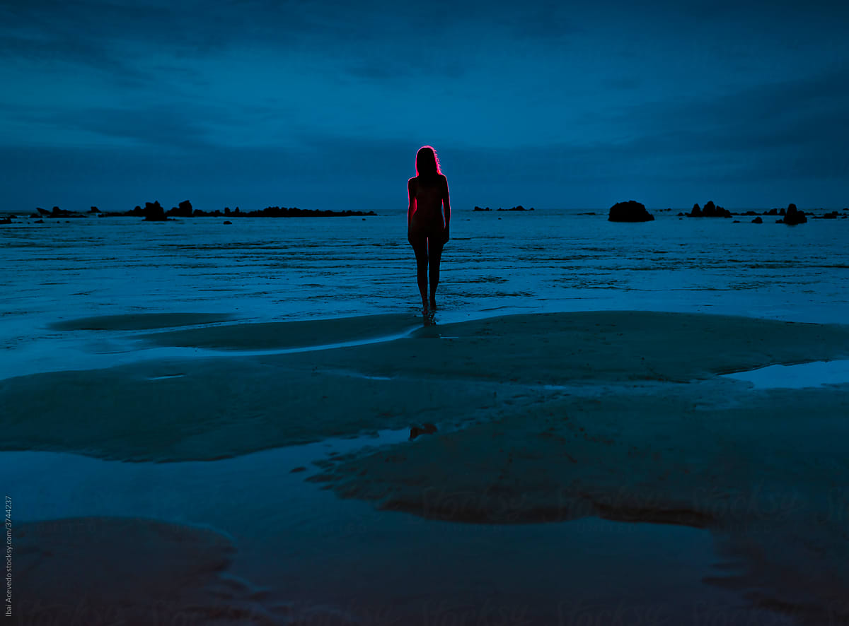 Red woman silhouette in a surreal beach