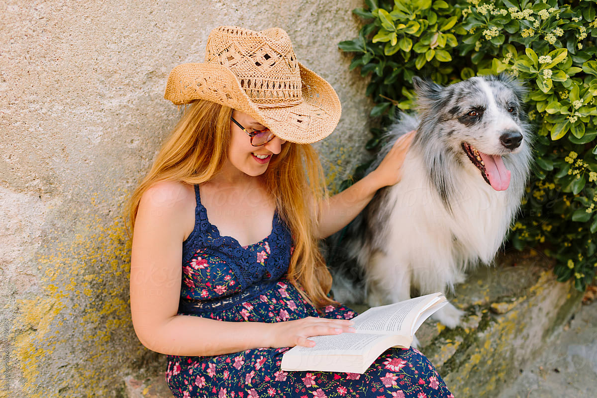 Smiley woman reading with her dog