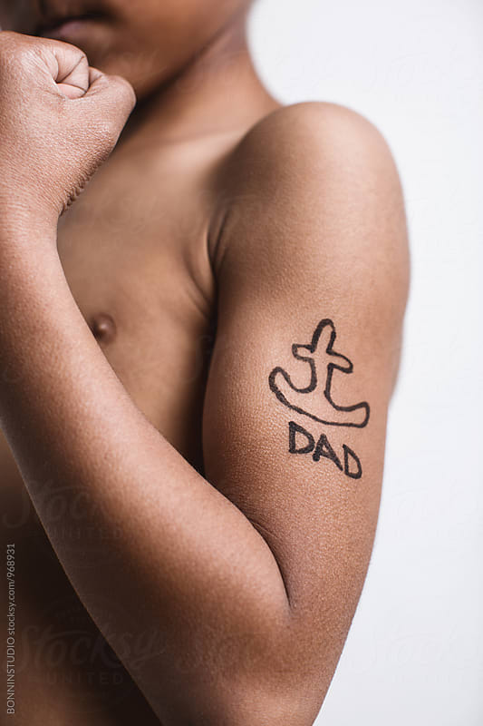Closeup of a little boy with a funny tattoo on biceps.