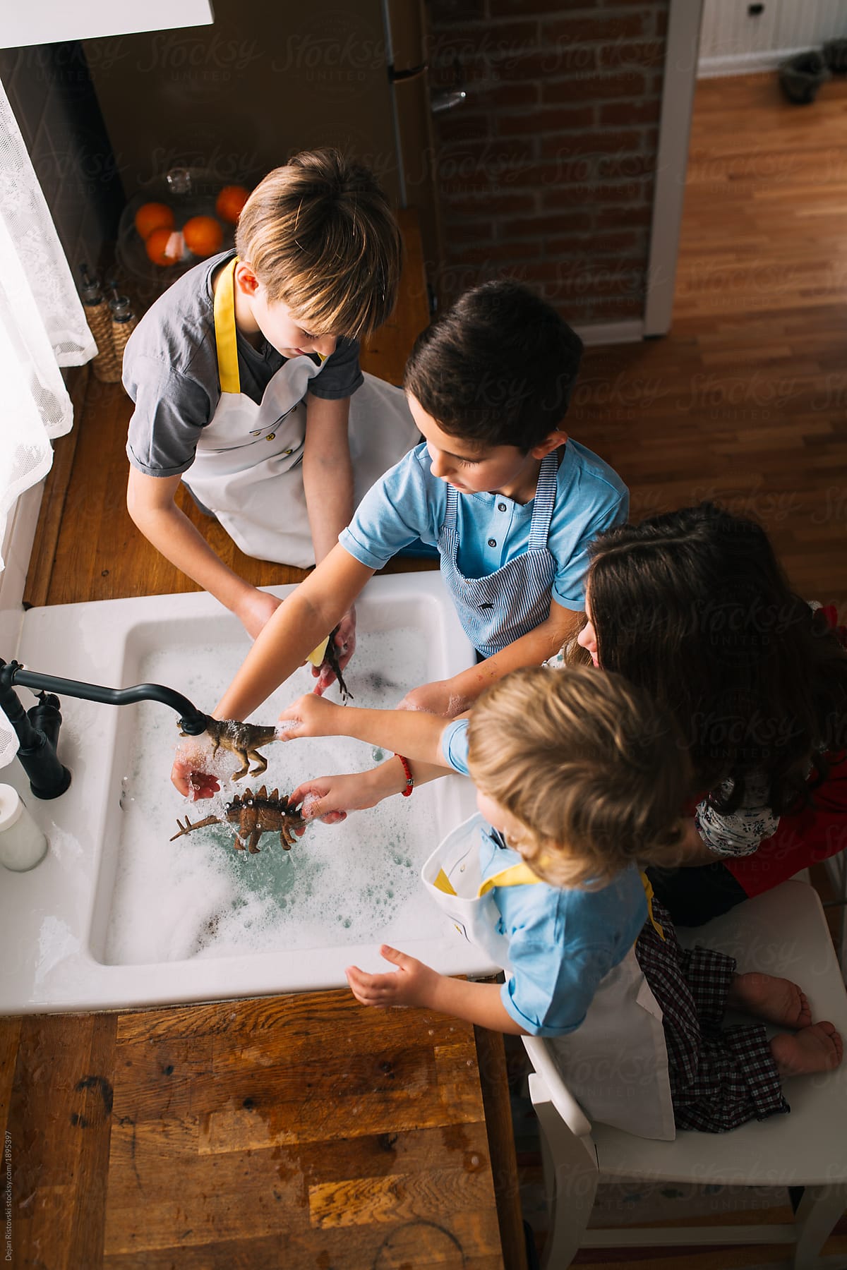 Children playing washing toys into the sink