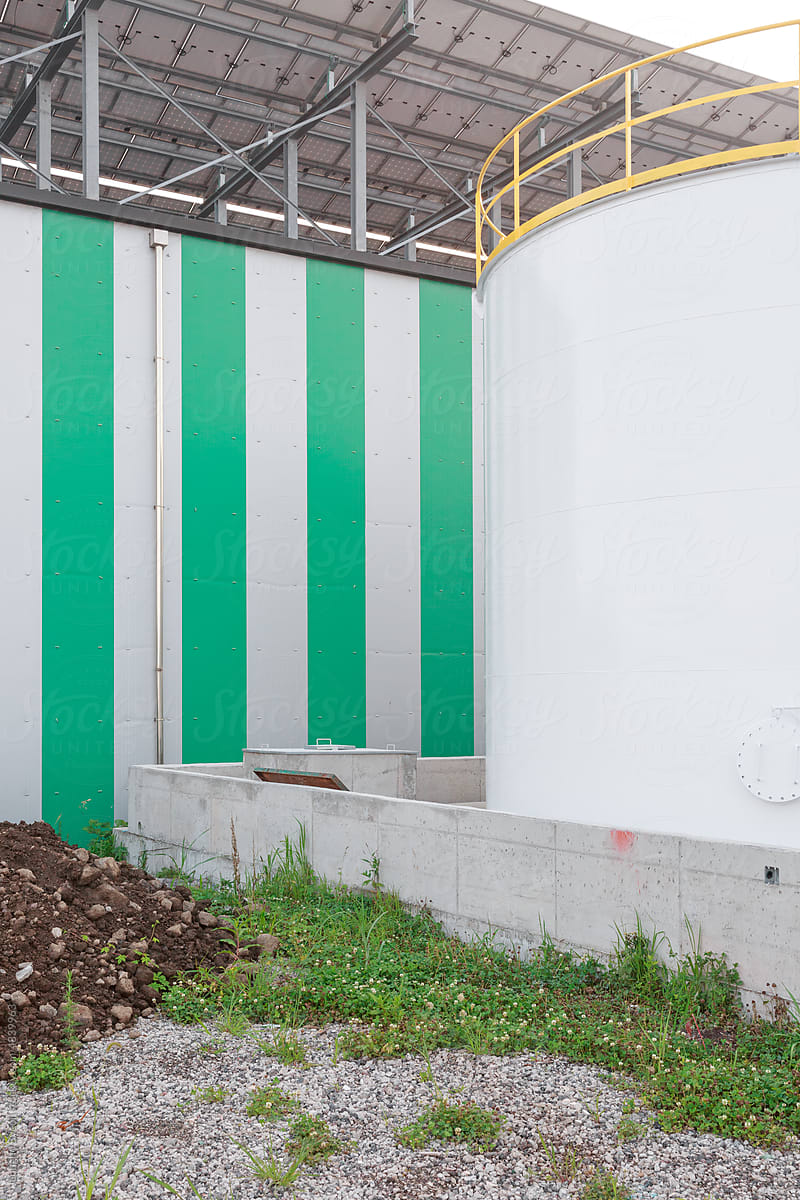 White Storage Tank and Green Striped Warehouse.