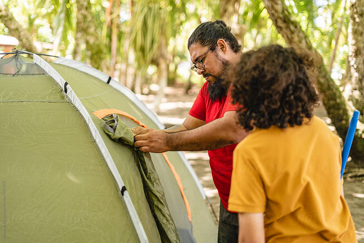 Man and his son setting up a camping tent