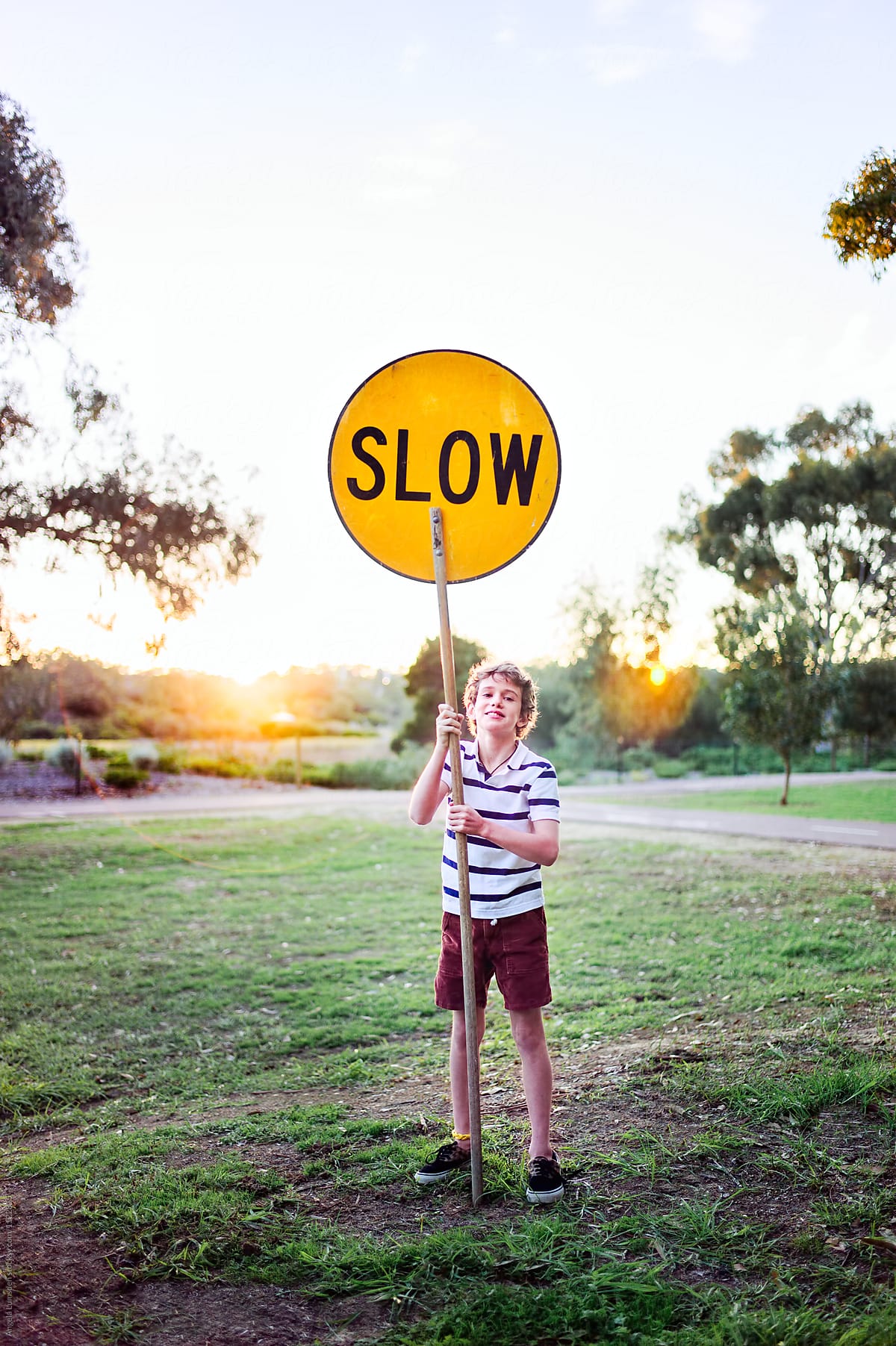 Boy with a slow sign in a park
